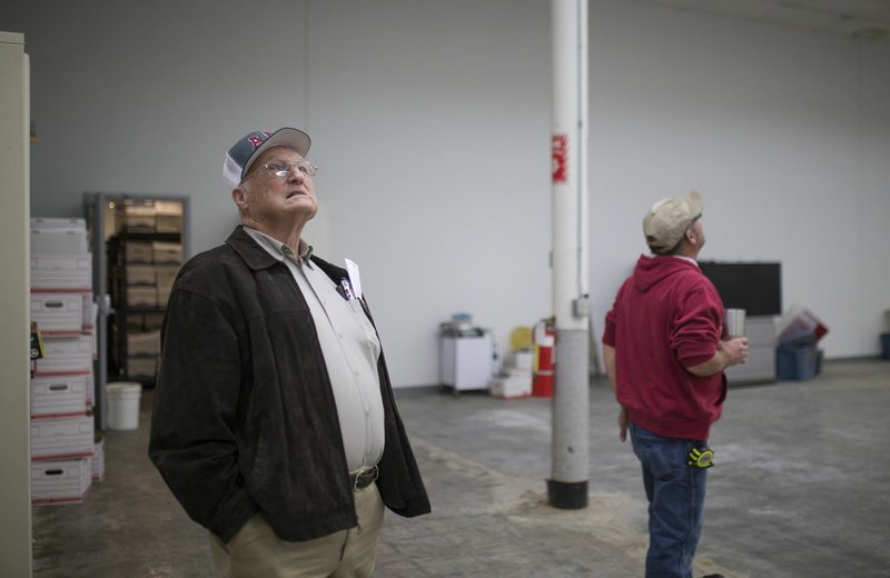NWA Democrat-Gazette/CHARLIE KAIJO Benton County Commissioner John Brown and Election Commissioner Mike Sevak examine the ceilings Nov. 20 at the old Kmart building on Walnut Street in Rogers. Benton County officials toured the old building to get an idea of how well it will suit their needs. The Election Commission is supposed to be the first to move since they need room for new voting machines.