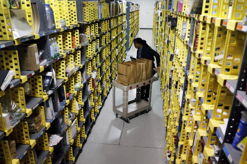 FILE - In this Tuesday, Dec. 22, 2015, file photo, Amazon Prime employee Alicia Jackson hunts for items at the company's urban fulfillment facility that have been ordered by customers, in New York. Shoppers are expected to spend $6.6 billion on Cyber Monday, Nov. 27, 2017, up more than 16 percent from a year ago, according to Adobe Analytics, the research arm of software maker Adobe. And more people will be picking up their phones to shop: Web traffic from smartphones and tablets is expected to top desktop computers for the first time this year, Adobe said. (AP Photo/Mark Lennihan, File)
