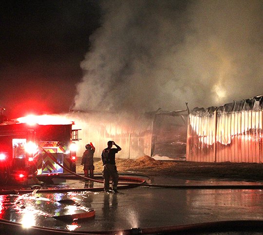 The Sentinel-Record/Richard Rasmussen HAY BARN FIRE: Hot Springs firefighters work to contain a fire that erupted in a storage barn full of hay at 439 Broadway St. Monday night. The interior of the barn, belonging to Williams Brothers Feed Store, 401 Broadway, was “fully involved” when firefighters arrived, Fire Chief Ed Davis said. While they were able to get it under control, it was “going to take a long time to overhaul” everything.