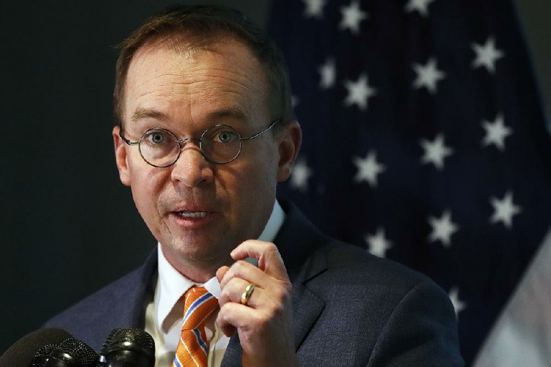 Mick Mulvaney speaks during a news conference after his first day as acting director of the Consumer Financial Protection Bureau on Monday in Washington.
