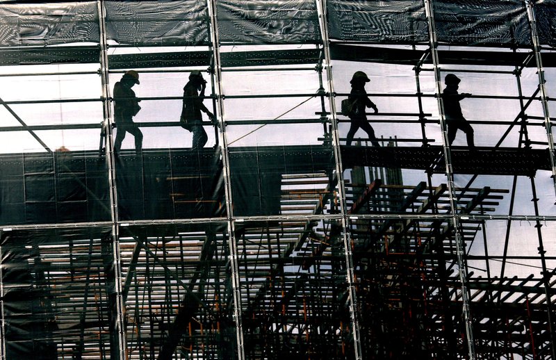 Construction workers walk on scaffolding Tuesday at a construction site Bangkok, Thailand. (AP Photo/Sakchai Lalit)