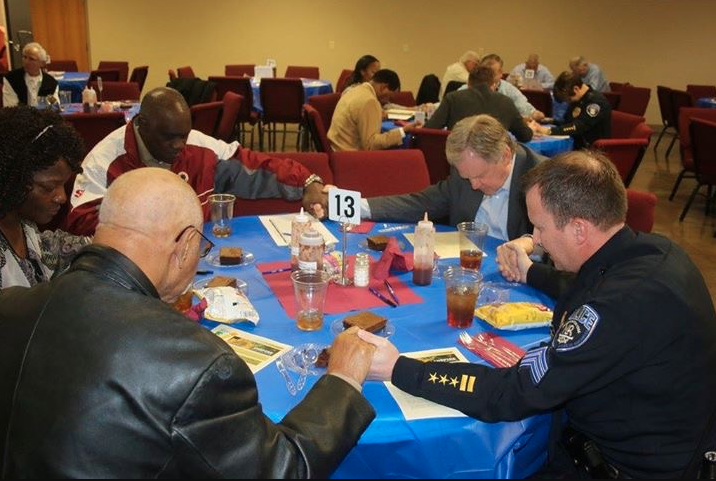 North Little Rock Police Department Sgt. Brian Dedrick prays with central Arkansas pastors at a 2016 meeting.