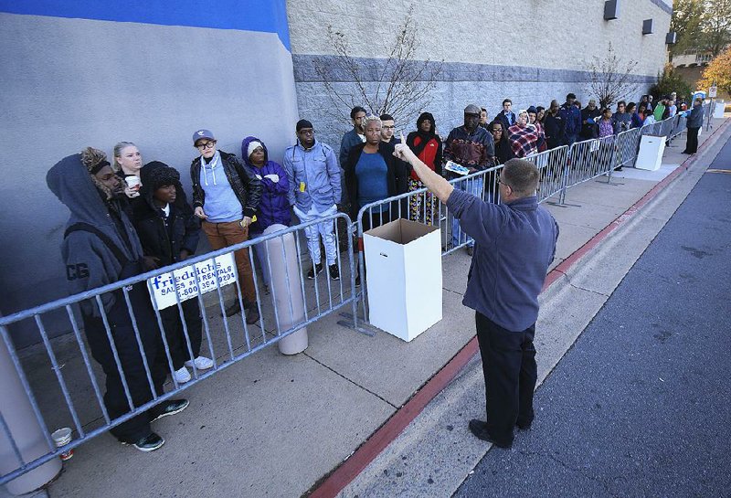A Best Buy employee gives instructions to shoppers Friday morning as they wait for the store on Chenal Parkway in west Little Rock to open. Retailers around the country reported better-than-expected results from the five-day Thanksgiving weekend shopping period. 
