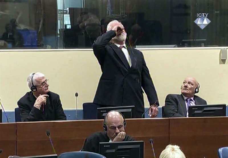 Slobodan Praljak downs poison from a bottle Wednesday during a war-crimes tribunal in The Hague, Netherlands, in this photo provided by the International Criminal Tribunal for the former Yugoslavia. 