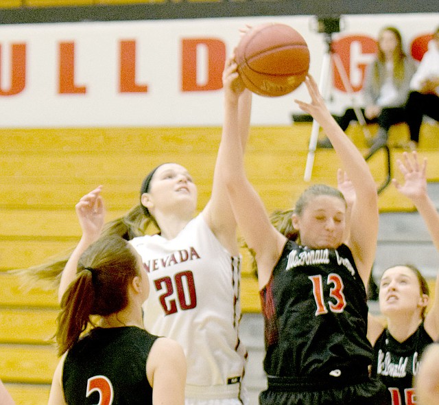 RICK PECK SPECIAL TO MCDONALD COUNTY PRESS McDonald County's Meagan Mills takes a rebound away from Nevada's Teagan Charles during the Lady Mustangs' 51-47 loss in the opening round of the Freeman Sports Medicine CJ Classic Girls Basketball Tournament on Monday night at Carl Junction High School.