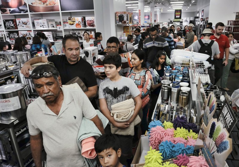 FILE - In this Thursday, Nov. 23, 2017, file photo, shoppers wait in a checkout line at a J.C. Penney store in Glendale, Calif. The U.S. economy grew at an annual pace of 3.3 percent from July through September, fastest in three years. The U.S. Commerce Department said Wednesday, Nov. 29, that third-quarter growth exceeded the 3 percent expansion it originally reported. (AP Photo/Richard Vogel, File)