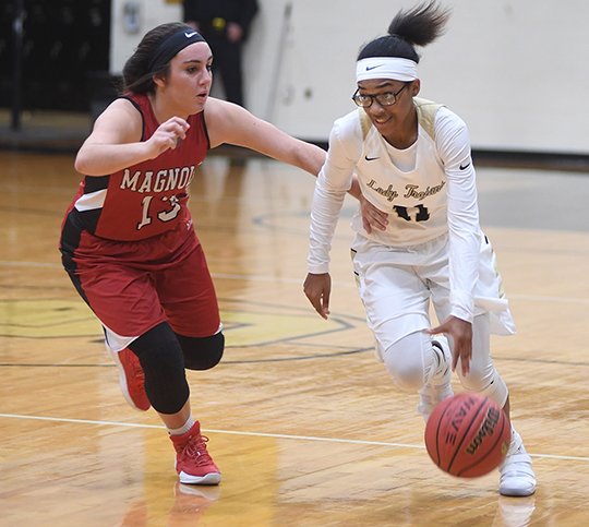 The Sentinel-Record/Mara Kuhn DRIVE IN: Hot Springs guard Kiah Beauford (11) drives past Magnolia's Kendall McMahen (13) Tuesday night at Trojan Fieldhouse. The Lady Trojans forced 19 turnovers in a 53-21 win.