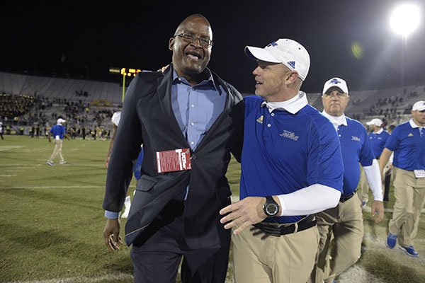 Tulsa head coach Philip Montgomery, right, is congratulated by athletic director Dr. Derrick Gragg after an NCAA college football game against Central Florida on Saturday, Nov. 19, 2016 in Orlando, Fla. Tulsa won 35-20. (AP Photo/Phelan M. Ebenhack)

