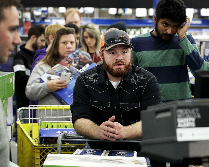 Customers crowd the checkout line at a Best Buy store in Overland Park., Kan., on Thanksgiving Day.
