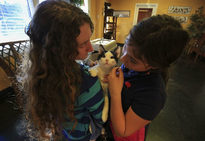 Kelly Page (left) and her daughter Marley, 10, pick up their cat, Jingles, on Thursday afternoon at Arkansans for Animals Inc. in Little Rock after the cat was sterilized during the Pulaski County Big Fix. The spay/neuter program was funded through voluntary $5 donations on Pulaski County residents’ tax bills.