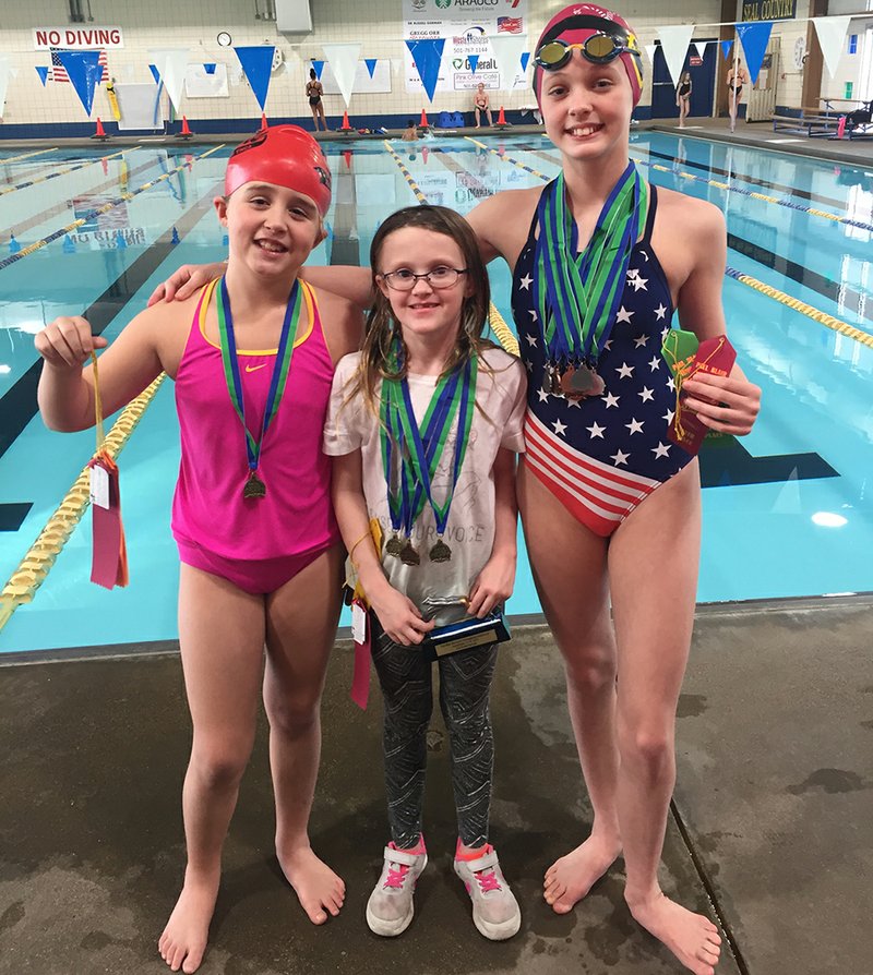 Submitted photo MAKING A SPLASH: Members of the Hot Springs YMCA Seals display their awards from the Paul Blair invitational meet. Aubrey Schmitt, center, won two events and was the high-point award winner for the 8-and-under division while Audrey Simons, left, and Emma Crowe each won an event at the meet.