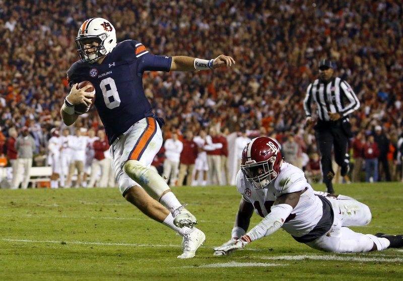 Auburn quarterback Jarrett Stidham (8) gets past Alabama linebacker Dylan Moses (18) to carry the ball in for a touchdown during the second half of the Iron Bowl NCAA college football game, Saturday, Nov. 25, 2017, in Auburn, Ala. (AP Photo/Butch Dill)