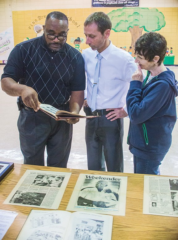Anthony Wayne Hoskins, left, discusses some of the memorabilia from Pine Street School with Charles 
Finkenbinder and his mother, Donna Velocci, who was visiting from New York and plans to retire in Conway. The three met recently in the old Pine Street High School gymnasium, which is on the grounds of the Greater Pleasant Branch Baptist Church, to discuss plans for the Pine Street Community Museum in Conway.
