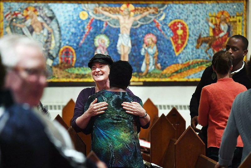 Isabelle Melese-d’Hospital (facing the camera) embraces Charleen Ward during a service at St. Margaret’s Episcopal Church in the District of Columbia. “I needed to come after the [2016] election… . I needed to have that family support of the church,” Ward said.