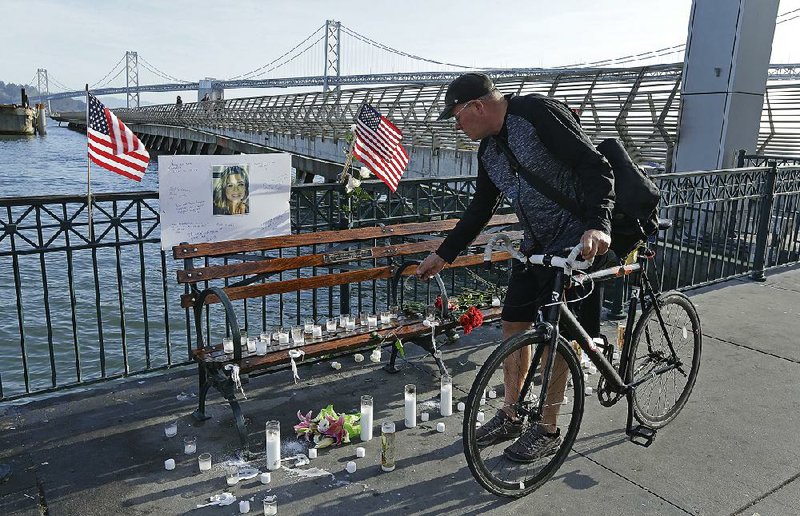 Craig Warner leaves a bell Friday at a memorial site on Pier 14 in San Francisco, where Kate Steinle was shot dead in 2015. 