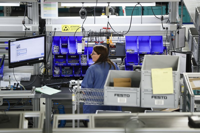 FILE - In this Wednesday, May 17, 2017, file photo, an employee stands at her workstation at the Festo distribution center in Mason, Ohio. On Friday, Dec. 1, 2017, the Institute for Supply Management, a trade group of purchasing managers, reports on U.S. manufacturing for November. (AP Photo/John Minchillo, File)