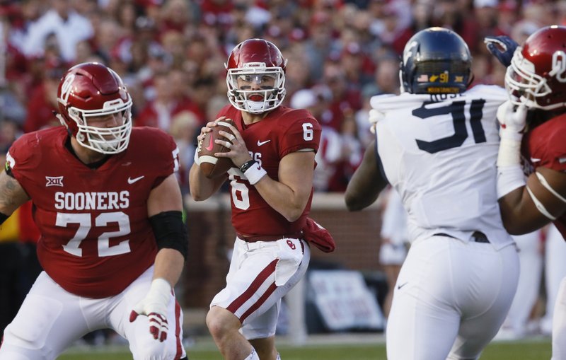 In this Saturday, Nov. 25, 2017. file photo, Oklahoma quarterback Baker Mayfield (6) prepares to pass in the second quarter of an NCAA college football game against West Virginia in Norman, Okla. 