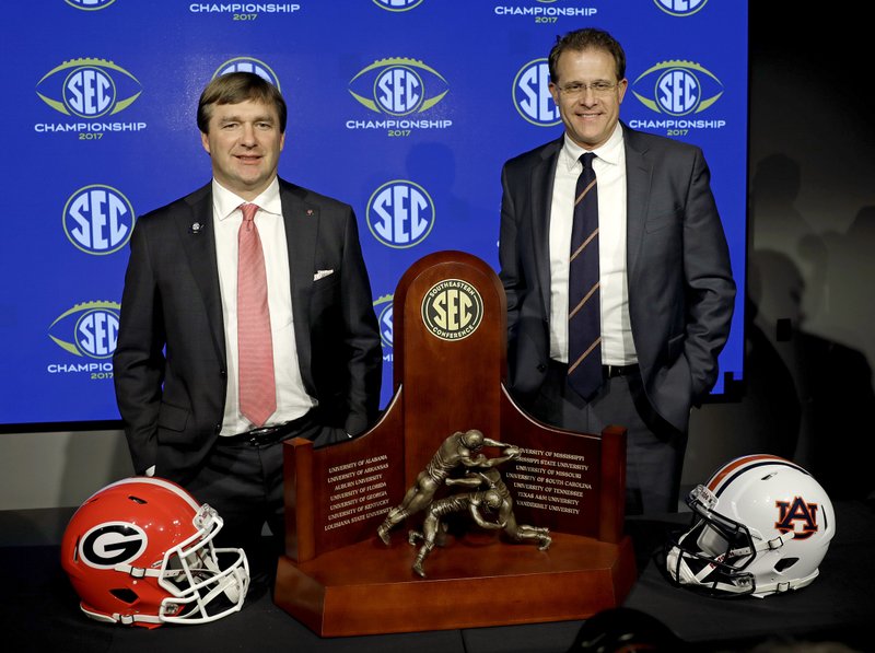 The Associated Press FAMILIAR FOES: Georgia head coach Kirby Smart, left, and Auburn head coach Gus Malzahn pose with the SEC championship trophy during an NCAA football news conference in Atlanta Friday. Auburn handed Georgia its first loss of the season Nov. 11, rolling to a 40-17 victory.