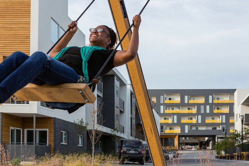 Courtesy Photo A resident tries out Craig Colorusso's "Sound Swings," a trio of swings that play a musical composition when activated by the motion of people swinging, a new installation at Uptown Fayetteville Apartments, 3959 N. Steele Boulevard in Fayetteville. The apartment complex will host "The Art of Craig Colorusso: A Pop-Up Exhibit" Dec. 14-17. The public is invited to an opening night party at 7 p.m. Dec. 14, and Sun Boxes will be displayed in the Uptown Courtyard from noon to 5 p.m. Dec. 16. The public is invited. Information: (479) 966-7490.