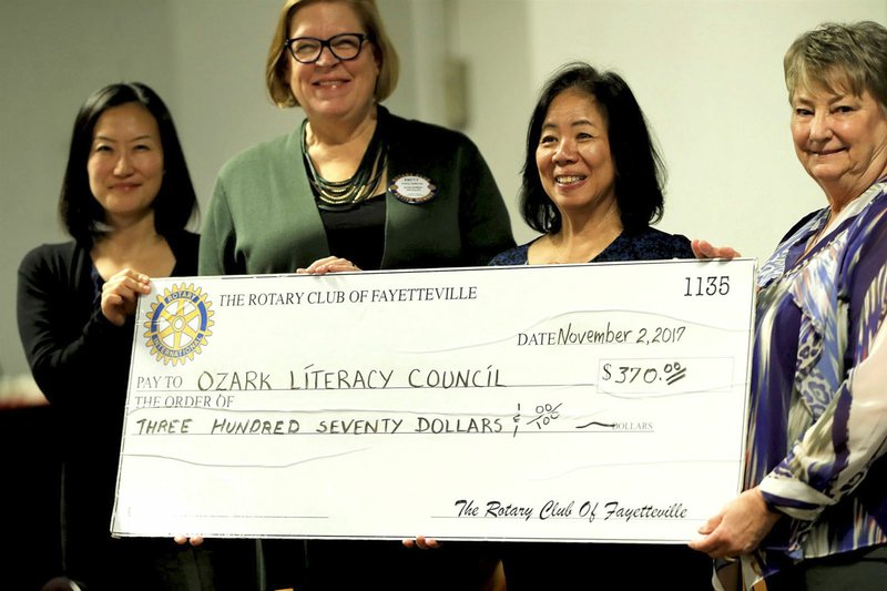 Courtesy photo Mary Alice Serafini (right), president of Rotary Club of Fayetteville, presents a check for $300 collected from Rotarians to Patty Sullivan, executive director, Ozark Literacy Council; and Mina Phebus, program director, Ozark Literacy Council, as Chung Tan (left), chairwoman of the board of the Fayetteville Chamber of Commerce, looks on. Ozark Literacy Council provides instruction to people to help increase their ability to communicate in English while learning U.S. systems, customs and culture and skills useful in life, academic and workplace applications.