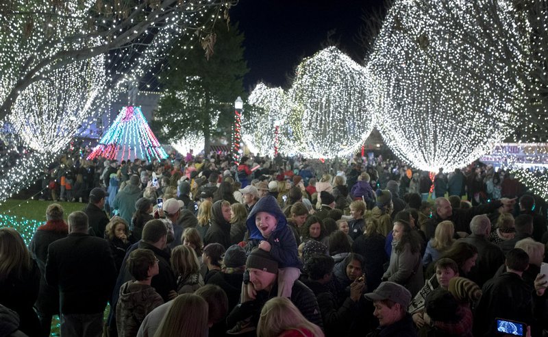 Visitors admire Christmas lights during the Lighting of the Square in Bentonville. The Christmas parade will traverse the square at 11 a.m. Dec. 9.