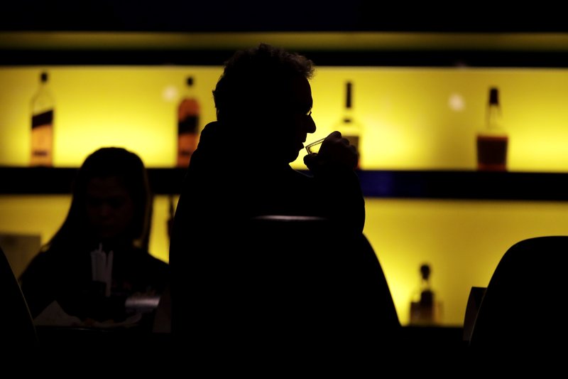 In this Nov. 30, 2017, photo, Dennis Dubrow, 62, Oceanport, N.J., takes a sip of his drink while having a meal at the William Hill Sports Bar in West Long Branch, N.J. The bar is located inside the Monmouth Park racetrack building. With banks of TVs tuned to all-sports stations and a spacious bar, the lounge is a sports gamblers paradise-in-waiting. All that's standing in its way: A 25-year-old federal law that bars betting on sports in most states. The high court is weighing On Dec. 4, whether a federal law that prevents states from authorizing sports betting is constitutional. If the Supreme Court strikes down the law, giving sports betting the go-ahead, dozens of states could quickly make sports betting legal. (AP Photo/Julio Cortez)