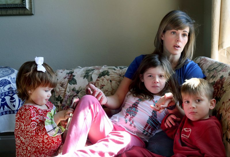 Jillayne Tompkins sits Nov. 20 with three of her ÿve children Claire (from left), 1, Emalie, 7, and Lucas, 5, as she describes her family’s experience and evacuation while living in Puerto Rico during Hurricane Maria. The Tompkins family is now living in Northwest Arkansas in her mother-in-law’s home.