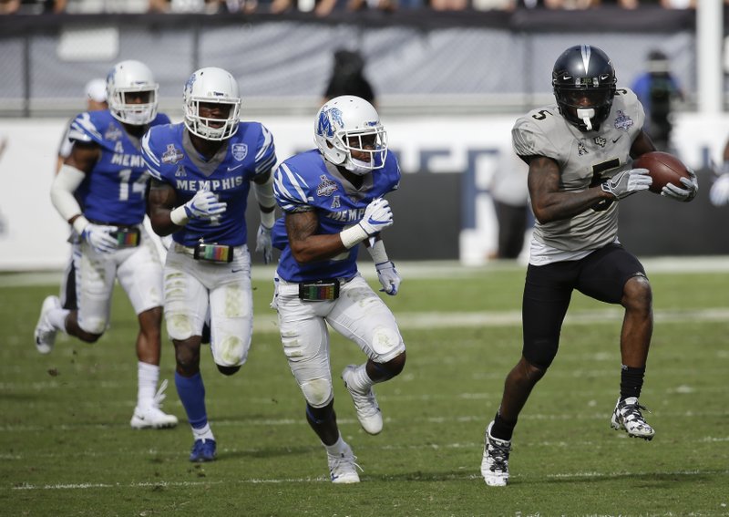 Central Florida wide receiver Dredrick Snelson, right, runs for yardage past Memphis defensive back Terrell Carter, center, during the first half of the American Athletic Conference championship NCAA college football game, Saturday, Dec. 2, 2017, in Orlando, Fla. (AP Photo/John Raoux)
