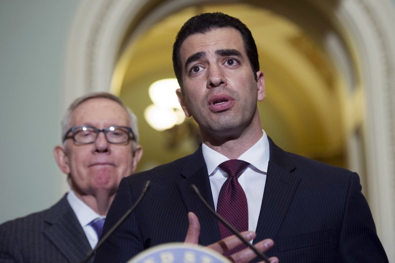 This Nov. 14, 2016 file photo Rep.-elect Ruben Kihuen, D-Nev.,right, speaks with reporters as Sen. Harry Reid, D-Nev., left, listens on Capitol Hill in Washington. 