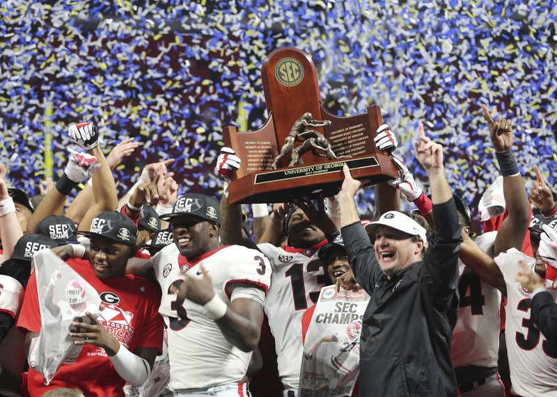 Georgia head coach Kirby Smart and team hold the SEC championship trophy after the Southeastern Conference championship NCAA college football game against Auburn, Saturday, Dec. 2, 2017, in Atlanta. Georgia won 28-7. (AP Photo/John Bazemore)