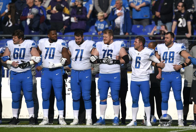 Members of the Detroit Lions lock arms during a rendition of the national anthem before an NFL football game against the Baltimore Ravens, Sunday, Dec. 3, 2017, in Baltimore. 