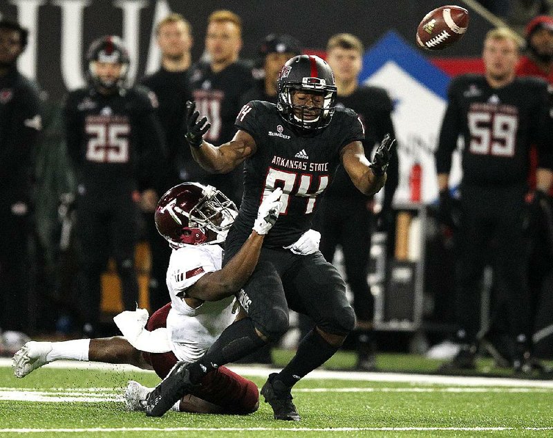 Troy cornerback Jalen Harris breaks up a pass intended for Arkansas State wide receiver Dijon Paschal (84) during the fourth quarter of the Red Wolves’ 32-25 loss Saturday at Centennial Bank Stadium in Jonesboro.