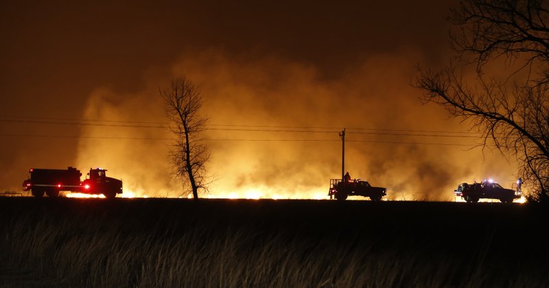 FILE - In this March 6, 2017 file photo, firefighters from across Kansas and Oklahoma battle a wildfire near Protection, Kan. The La Nina climate phenomenon in the south Pacific Ocean is contributing to weather conditions that are expected to be warm and dry with low humidity, leading to fears of a sharp increase in winter wildfires from the mid-South through the Great Plains. (Bo Rader/The Wichita Eagle via AP File)/The Wichita Eagle via AP)