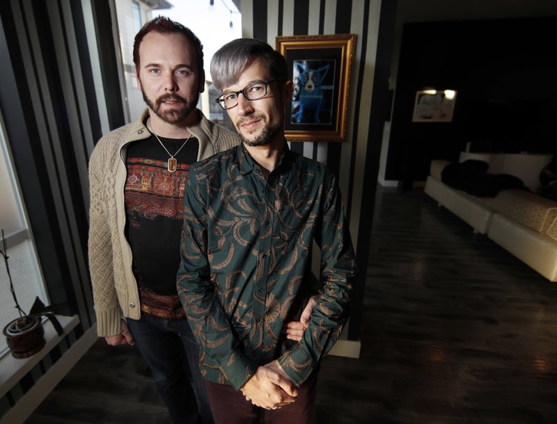 In this Nov. 28, 2017, photo, Charlie Craig and David Mullins are shown in their home in Denver. The Dec. 5, Supreme Court argument about a baker who refused to make a cake for the same-sex couple makes some civil rights lawyers think of South Carolina&#x2019;s Piggie Park barbecue. (AP Photo/David Zalubowski)
