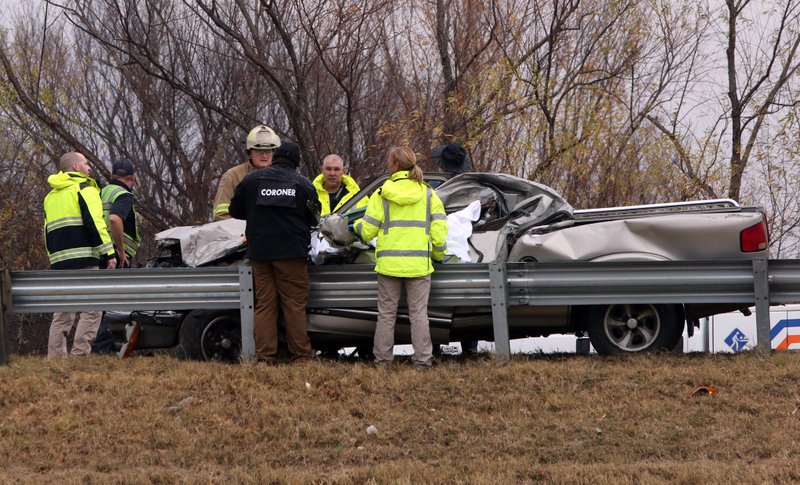 Emergency responders, including an official from the Pulaski County coroner's office, work the scene of a wreck on Interstate 30 in North Little Rock on Monday morning.
