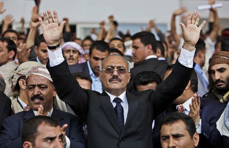 In this April 15, 2011, file photo then Yemeni President Ali Abdullah Saleh waves to supporters in Sanaa, Yemen. 