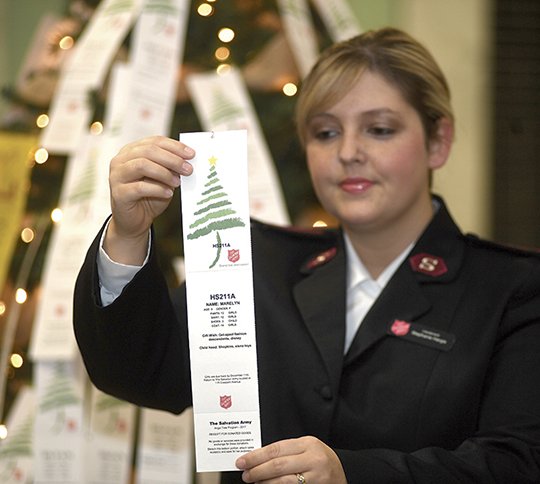The Sentinel-Record/Mara Kuhn ANGEL TREE: Lieutenant Stephanie Hargis with The Salvation Army of Hot Springs presents a tag from The Salvation Army's Angel Tree on Saturday at the Hot Springs Mall. Hargis says over 200 angels still await adoption.