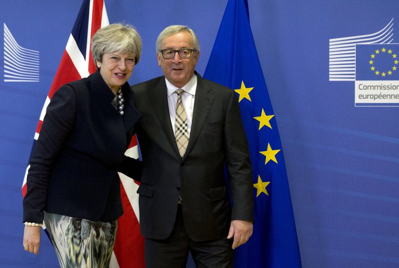 European Commission President Jean-Claude Juncker, right, greets British Prime Minister Theresa May prior to a meeting at EU headquarters in Brussels on Monday, Dec. 4, 2017. 