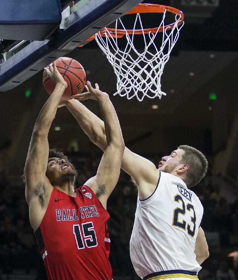 Ball State’s Zach Gunn (left) goes up for a shot against Notre Dame’s Martinas Geben during the Cardinals’ 80-77 victory over the No. 9 Fighting Irish on Tuesday in South Bend, Ind.