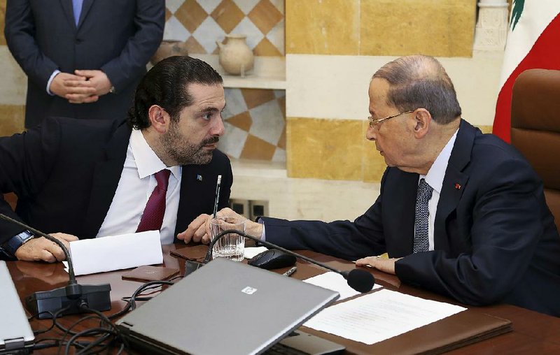 Lebanese Prime Minister Saad Hariri (left) talks with President Michel Aoun on Tuesday in the Presidential Palace at Baabda, Lebanon. Hariri formally revoked his surprise resignation after a consensus deal was reached with rival political parties.  