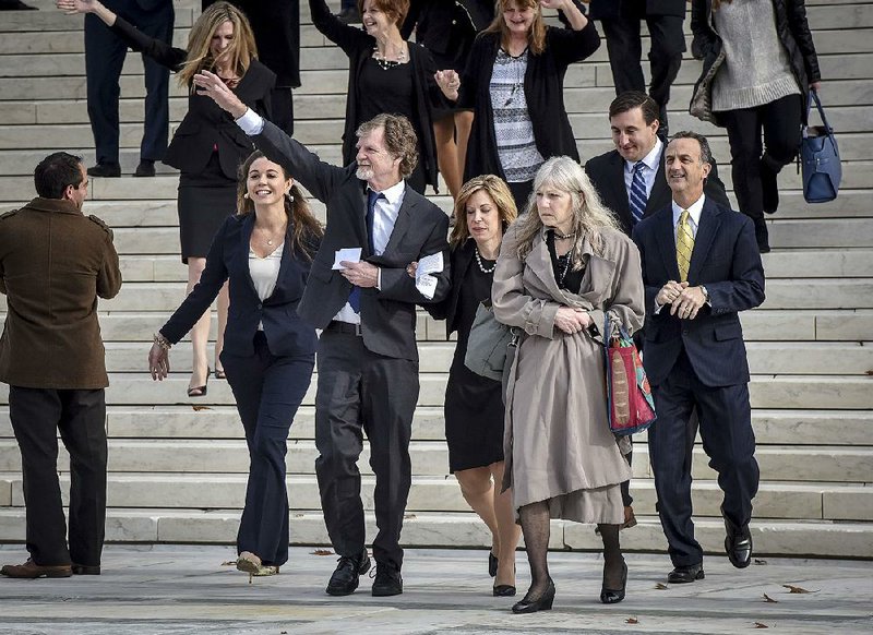 Colorado baker Jack Phillips waves to supporters Tuesday as he leaves Supreme Court after arguments were heard in his suit over his refusal to provide a wedding cake to a same-sex couple. 