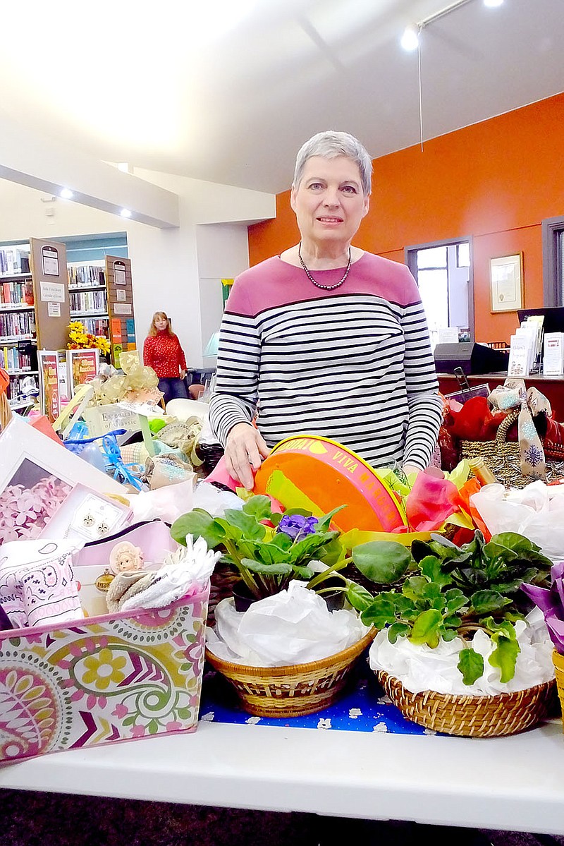 Lynn Atkins/The Weekly Vista Susan Ferraro stands among the 93 baskets she put together out of donated items for the Friends of the Library Fundraiser. The silent auction ends later today.