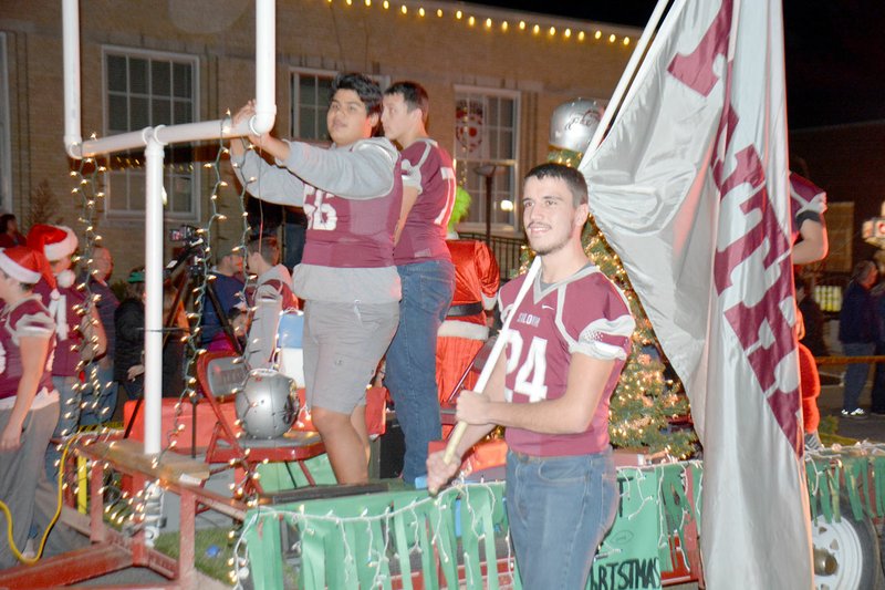 Graham Thomas/Herald-Leader Siloam Springs senior Payton Norberg, along with members of the Siloam Springs football team, walks with the Panther flag during the 2017 Siloam Springs Christmas Parade.