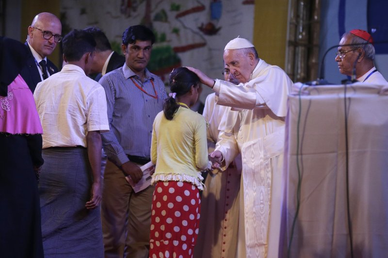 Pope Francis interacts with a Rohingya Muslim refugee at an interfaith peace meeting in Dhaka, Bangladesh, Friday, Dec. 1, 2017. Pope Francis ordained 16 priests during a Mass in Bangladesh on Friday, the start of a busy day that will bring him face-to-face with Rohingya Muslim refugees from Myanmar at an interreligious prayer for peace. (AP Photo/Aijaz Rahi)