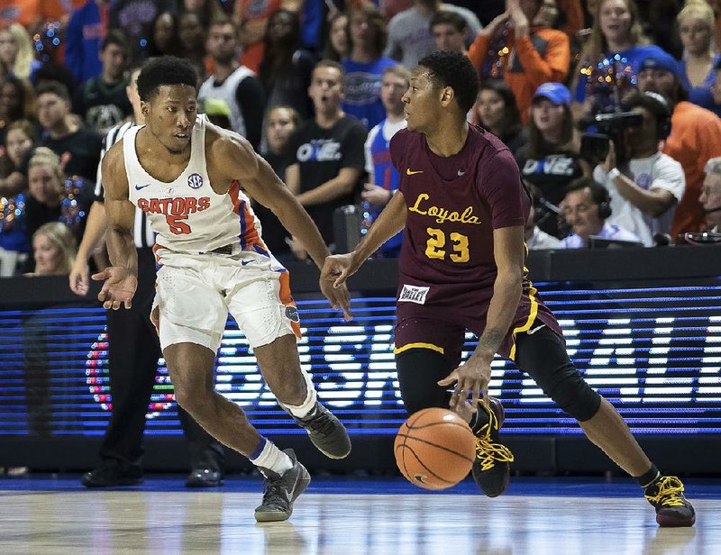 Loyola-Chicago guard Cameron Satterwhite (23) dribbles up the court against Florida guard KeVaughn Allen (North Little Rock) during the second half of the Ramblers’ 65-59 victory over the No. 5 Gators on Wednesday in Gainesville, Fla.  
