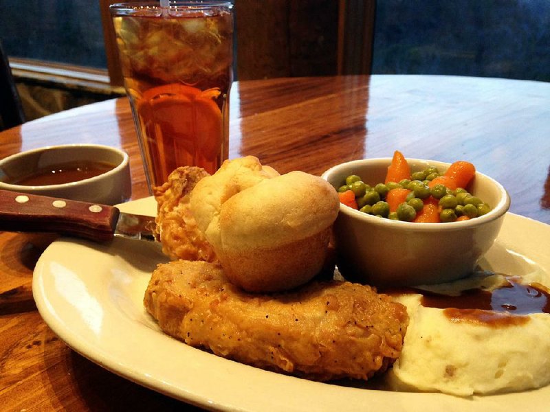 Fried pork chops come with a roll, mashed potatoes and peas and carrots. 

