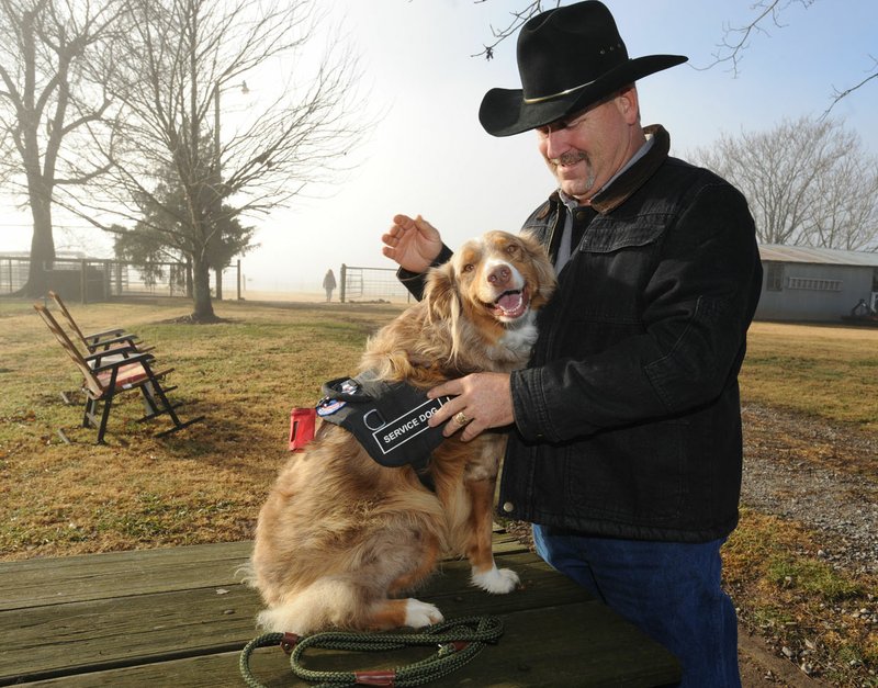 NWA Democrat-Gazette/ANDY SHUPE Jay Sanders of Fayetteville smiles as he greets Ruby, a service dog trained by Marsha Wyatt of Service Dogs of Distinction at her ranch south of Greenland. Sanders, a 15-year veteran of the U.S. Army, took Ruby home last December and continued her training. Service Dogs of Distinction is one of many in Northwest Arkansas asking the community for support.