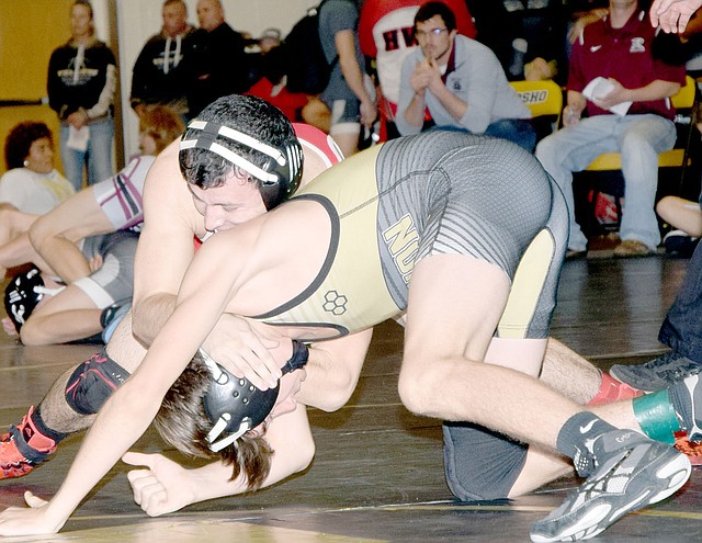 RICK PECK SPECIAL TO MCDONALD COUNTY PRESS McDonald County's Jakob Gerow tries to turn Lebanon's Cale Schmitz to his back in a 120-pound match at the Neosho Wrestling Tournament. Gerow pinned Schmitz on his way to winning the championship.