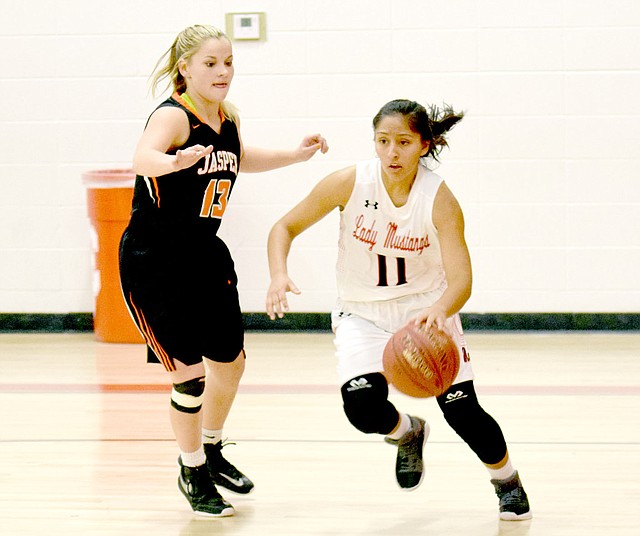 RICK PECK SPECIAL TO MCDONALD COUNTY PRESS McDonald County's Rita Santillan drives past Jasper's Terra Bowman during the Lady Eagles' 50-40 win in the CJ Classic Girls Basketball Tournament on Nov. 28 at Carl Junction High School.