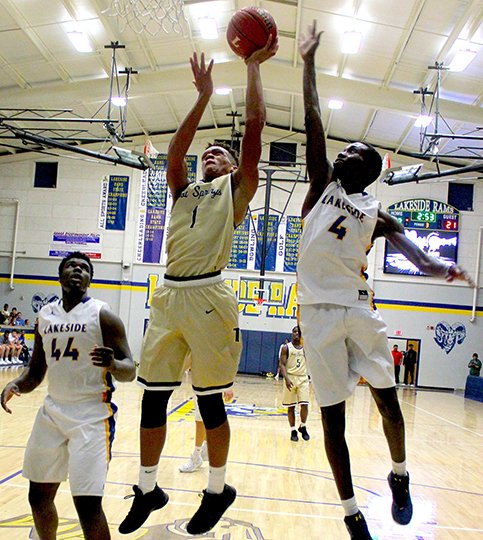 The Sentinel-Record/Mandie Gober POST PRESENCE: Hot Springs forward Santiair Thomas (1) goes up for a shot as Lakeside's Phillip Gayle (4) defends and Andrew Igbokidi (44) looks on Tuesday night at Lakeside Athletic Complex. Thomas scored a game-high 14 points in a 46-32 win for the Trojans.